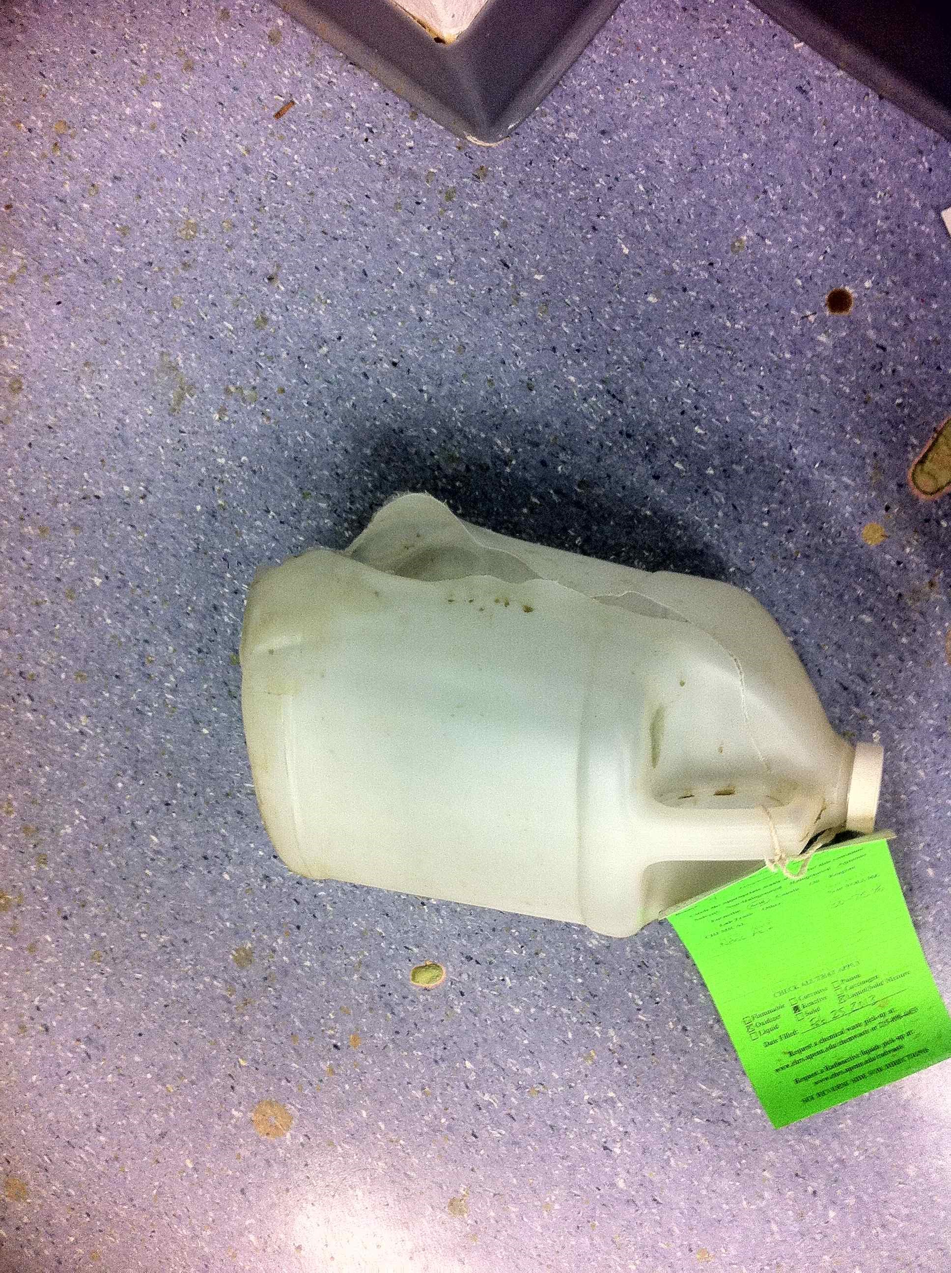 plastic 1-gallon bottle ruptured from nitric acid reaction with water in sealed bottle
